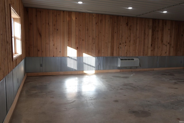 spare room featuring a wall mounted AC and wooden walls