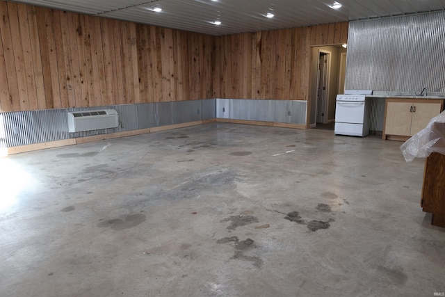 basement with sink, wooden walls, and a wall mounted AC