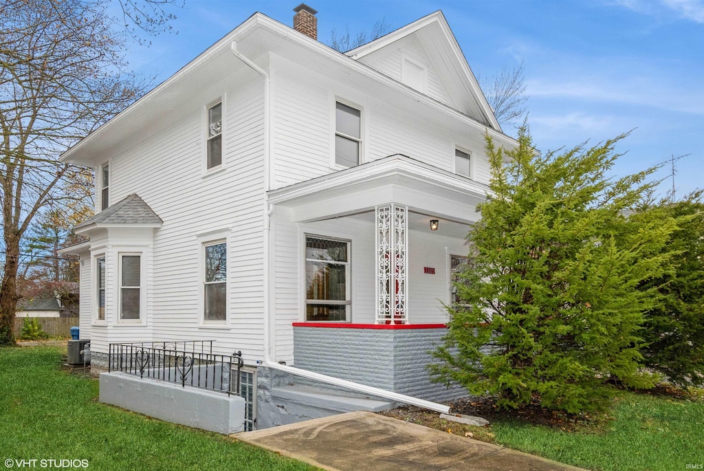 view of property exterior featuring a yard, covered porch, and central AC unit