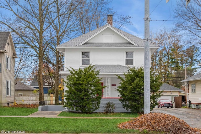 view of front of property with a garage, a front lawn, and an outdoor structure