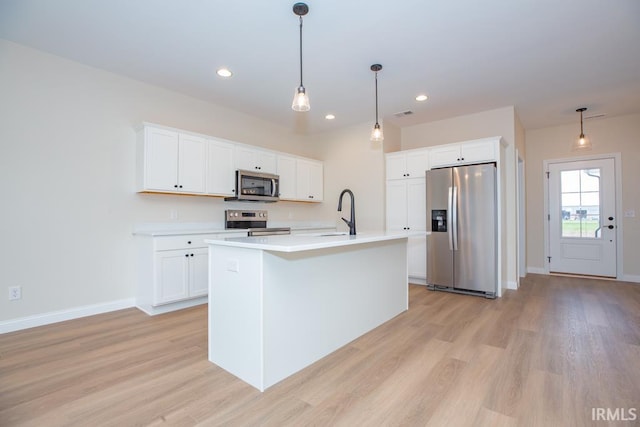 1609 Theo Dr Unit 2, Evansville, IN 47711 - kitchen with white cabinetry, a center island with sink, hanging light fixtures, and appliances with stainless steel finishes