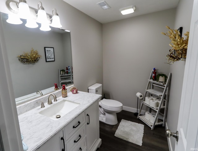 bathroom featuring vanity, wood-type flooring, and toilet