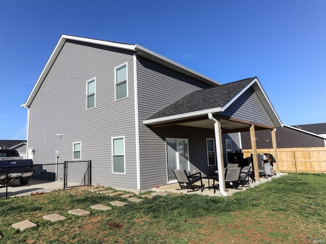 back of property featuring a lawn and a patio