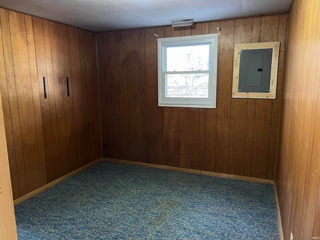 empty room featuring wood walls and electric panel