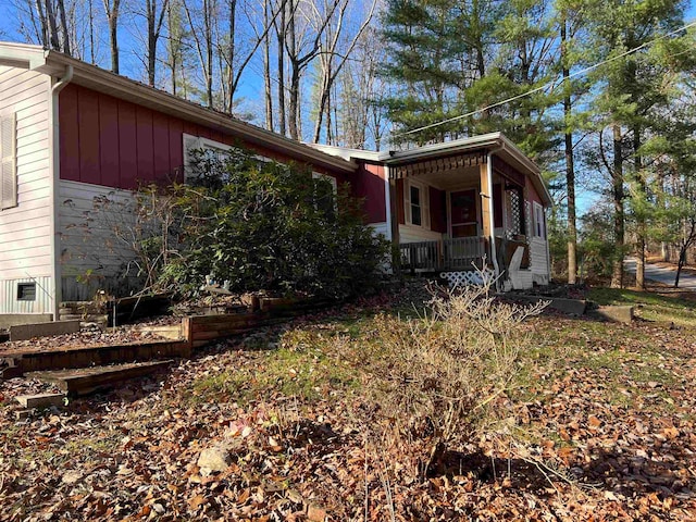 view of side of property featuring covered porch