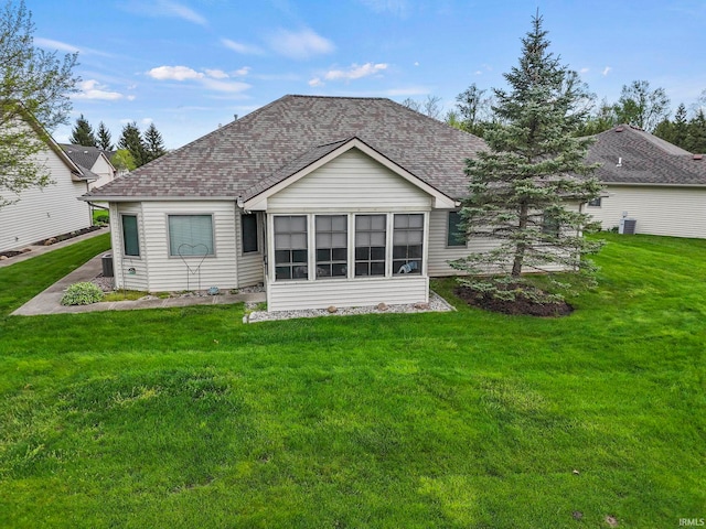 back of house with a sunroom and a yard