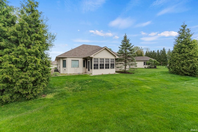 back of house with a lawn and a sunroom