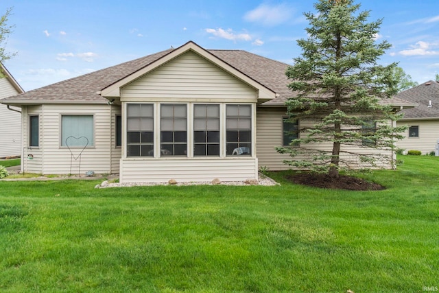 rear view of property featuring a yard