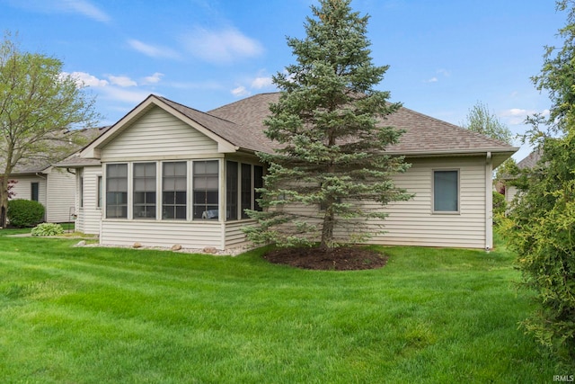 back of property featuring a lawn and a sunroom