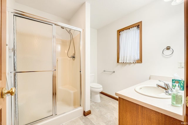 bathroom featuring vanity, toilet, and a shower with door