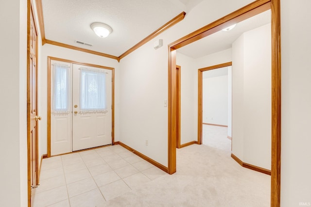 carpeted entryway featuring a textured ceiling and crown molding