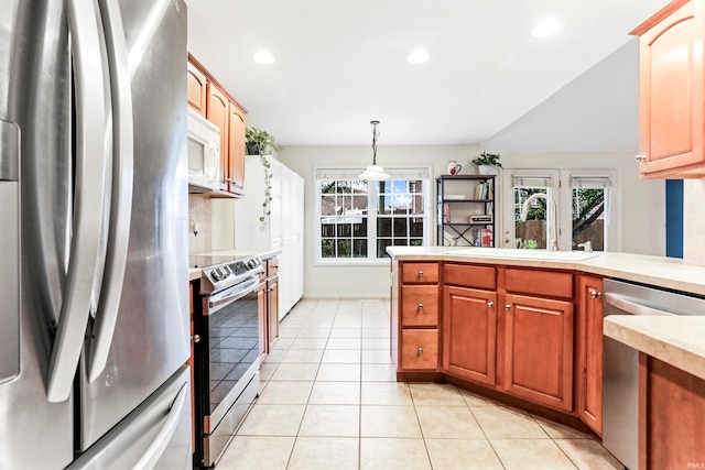 kitchen with a healthy amount of sunlight, sink, stainless steel appliances, and hanging light fixtures