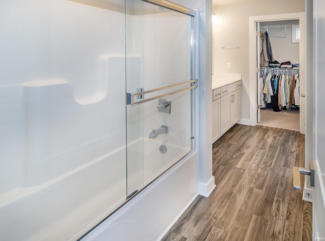 bathroom featuring combined bath / shower with glass door, hardwood / wood-style floors, and vanity