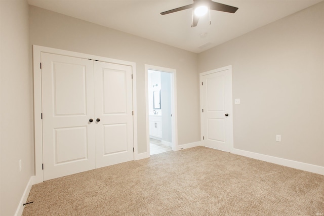 unfurnished bedroom featuring ceiling fan, a closet, carpet floors, and ensuite bath