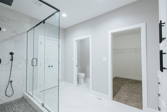 bathroom with toilet and a shower with shower door