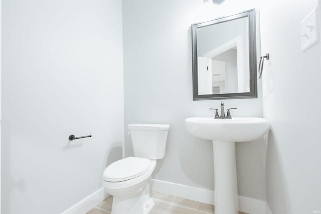 bathroom with hardwood / wood-style floors, toilet, and sink