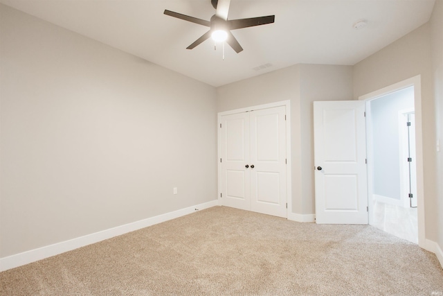 unfurnished bedroom with ceiling fan, light colored carpet, and a closet