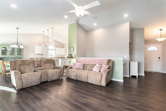 living room featuring ceiling fan with notable chandelier, dark hardwood / wood-style floors, and lofted ceiling