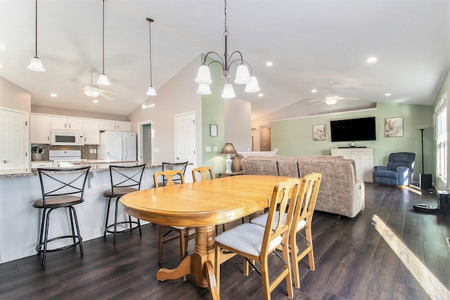 dining area featuring dark hardwood / wood-style flooring, ceiling fan with notable chandelier, and vaulted ceiling