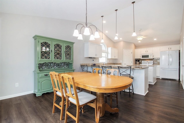 dining room featuring dark hardwood / wood-style floors, ceiling fan with notable chandelier, and high vaulted ceiling