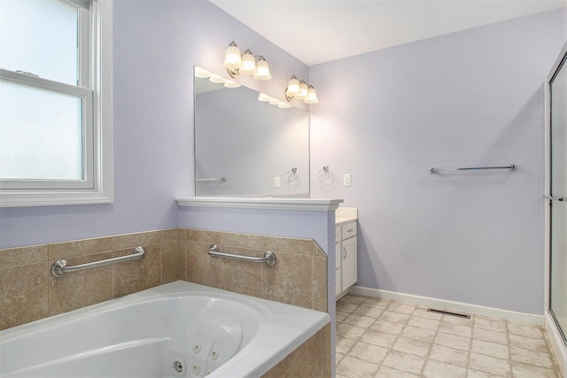 bathroom with vanity and tiled tub