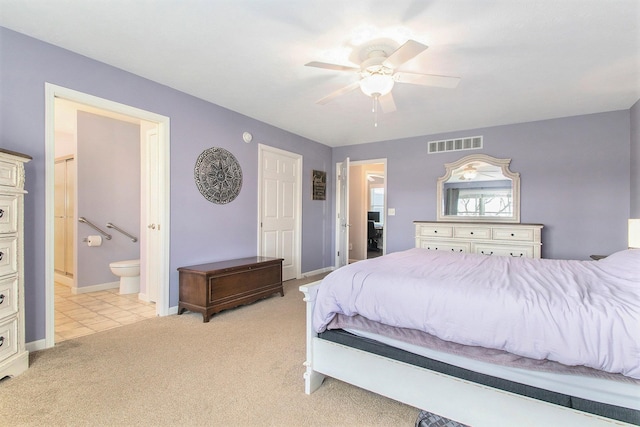 bedroom with ceiling fan, light carpet, and ensuite bath