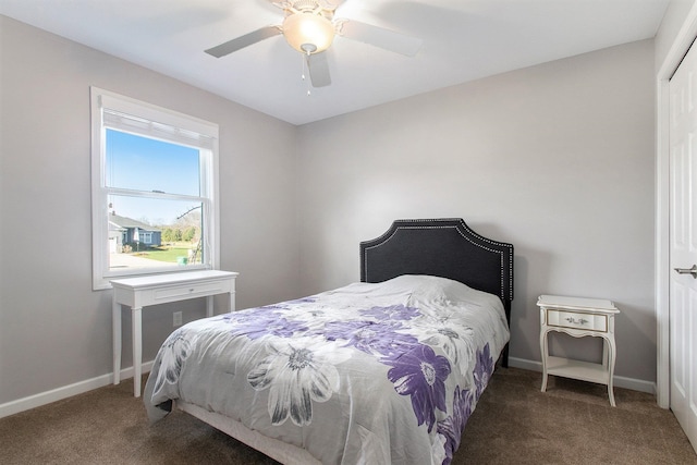 bedroom featuring dark colored carpet, a closet, and ceiling fan