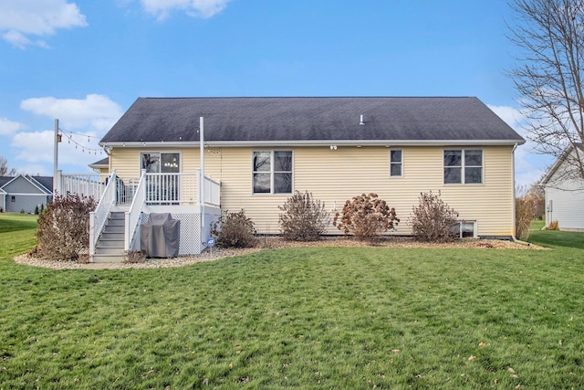 rear view of house featuring a lawn and a wooden deck