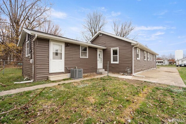 view of front of property featuring central air condition unit, a patio area, and a front lawn