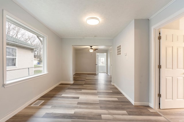 corridor featuring a textured ceiling and hardwood / wood-style flooring