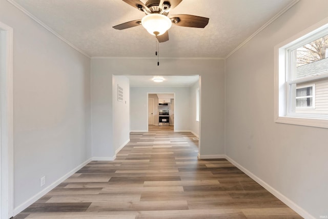 hallway with crown molding, light hardwood / wood-style flooring, and a textured ceiling