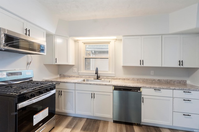 kitchen with sink, white cabinets, and stainless steel appliances