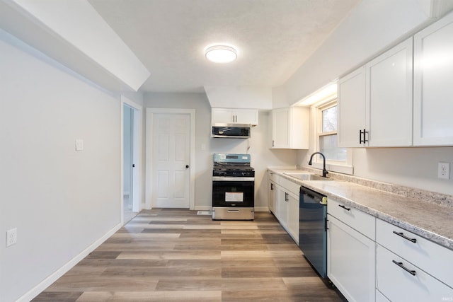 kitchen featuring white cabinets, light wood-type flooring, stainless steel appliances, and sink