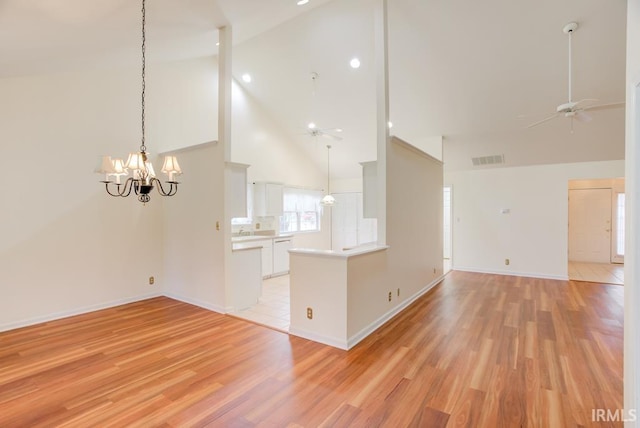 unfurnished living room with ceiling fan with notable chandelier, high vaulted ceiling, light hardwood / wood-style flooring, and sink