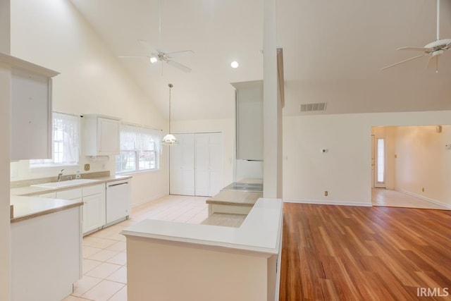 kitchen featuring dishwasher, sink, high vaulted ceiling, light hardwood / wood-style floors, and white cabinets