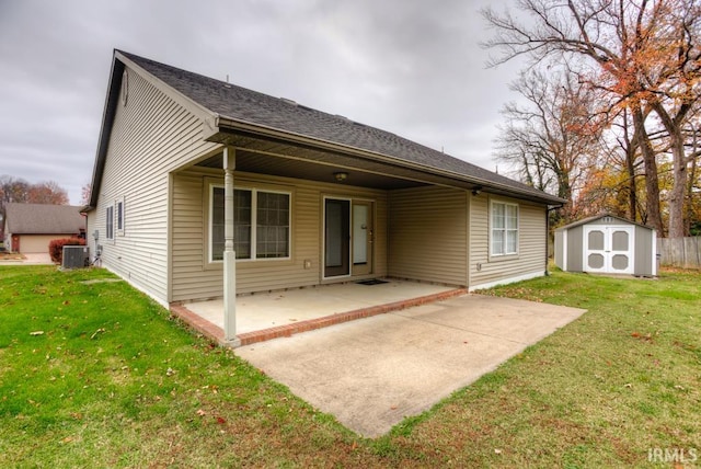 back of property with a patio, a shed, central AC unit, and a lawn