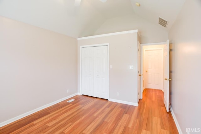 unfurnished bedroom featuring light wood-type flooring, a closet, ceiling fan, and lofted ceiling