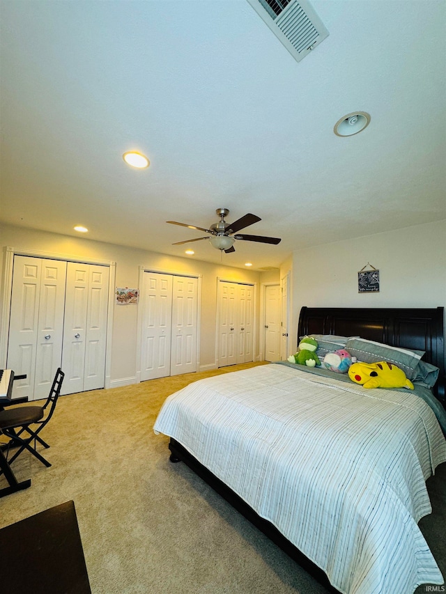 bedroom featuring ceiling fan, carpet, and two closets