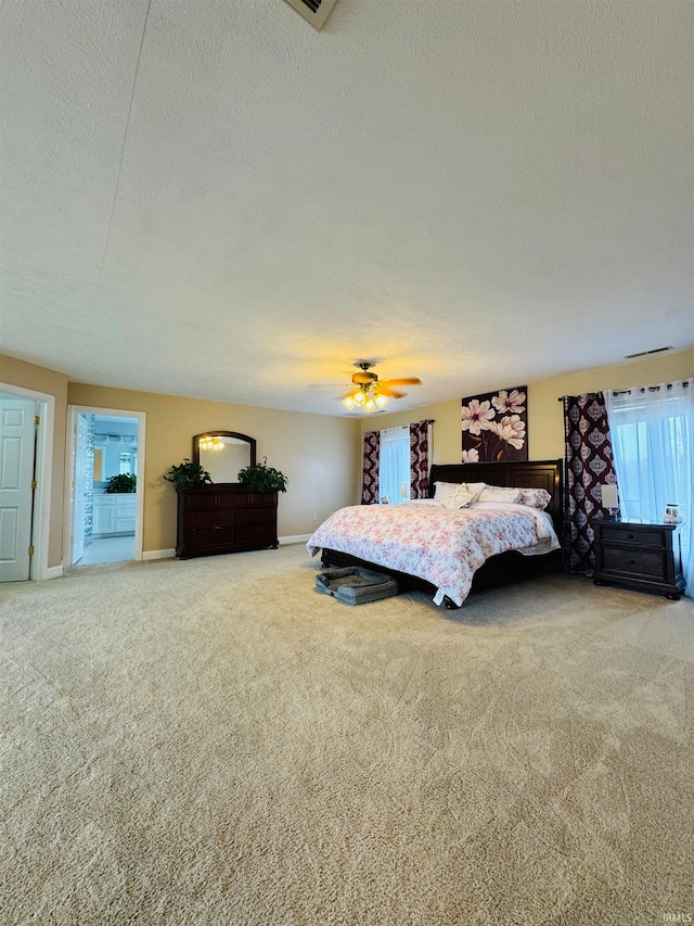 carpeted bedroom featuring ceiling fan and a textured ceiling