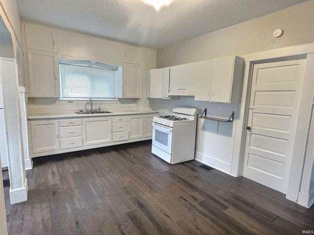 kitchen with white gas range oven, sink, white cabinets, dark hardwood / wood-style floors, and range hood