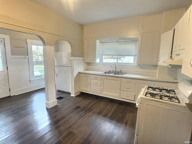 kitchen with white appliances, exhaust hood, sink, dark hardwood / wood-style floors, and white cabinetry