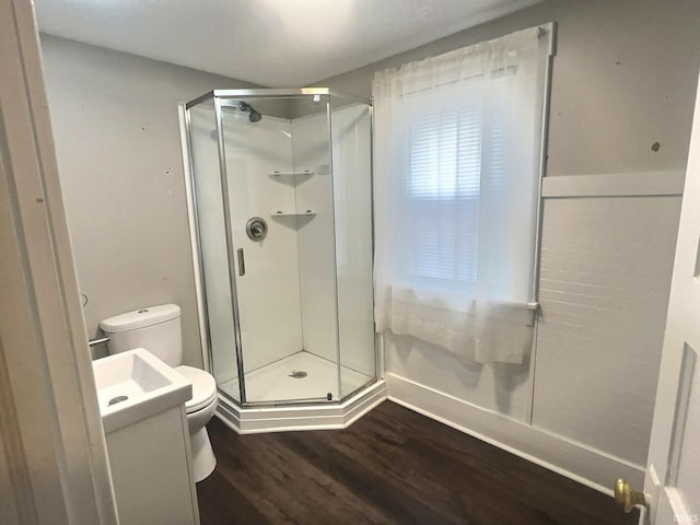 bathroom with toilet, hardwood / wood-style floors, vanity, and walk in shower