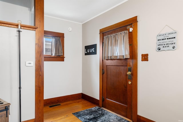 entrance foyer with light hardwood / wood-style floors and ornamental molding