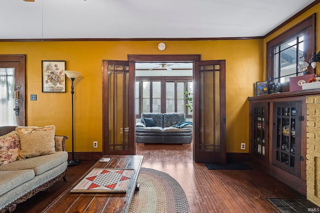 living room with ceiling fan, dark hardwood / wood-style flooring, ornamental molding, and french doors