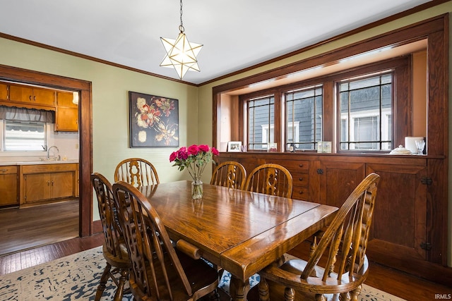 dining room with ornamental molding, dark wood-type flooring, and sink