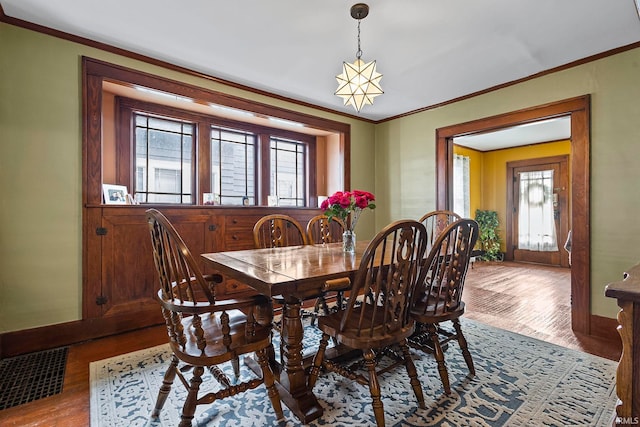 dining room featuring a wealth of natural light, light hardwood / wood-style flooring, and crown molding