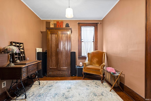 living area with crown molding and wood-type flooring