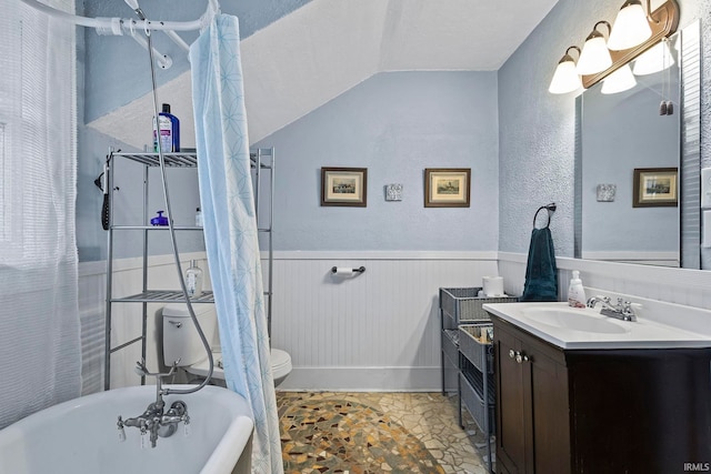 bathroom featuring vanity, lofted ceiling, a bath, toilet, and a textured ceiling