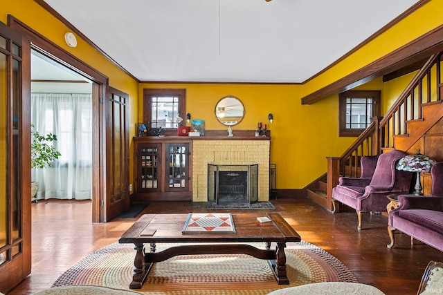 living room featuring a fireplace, hardwood / wood-style flooring, and ornamental molding