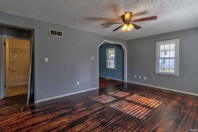 unfurnished room with ceiling fan, dark wood-type flooring, and a textured ceiling